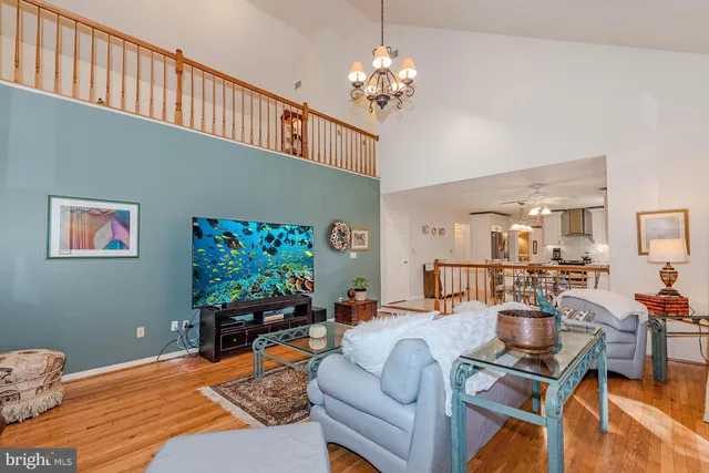 a living room with furniture a dining table and a chandelier