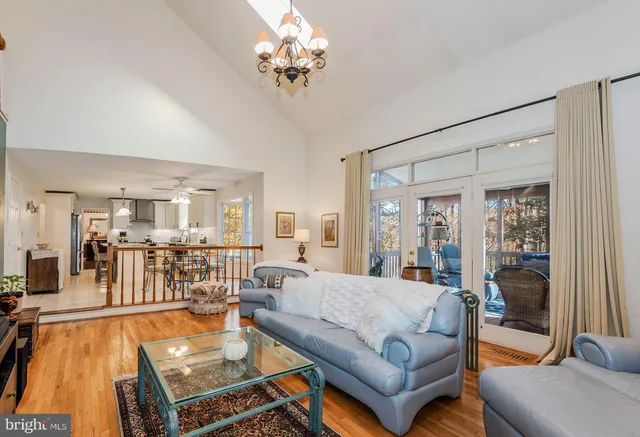 a living room with furniture a chandelier and a dining table