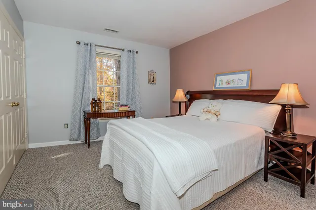 a bedroom with a bed and a lamp on the dresser