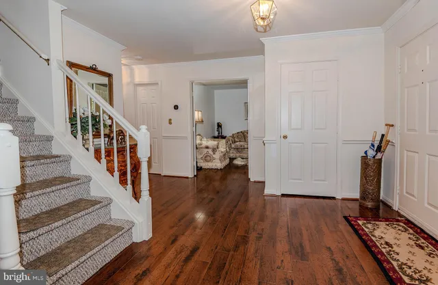 a view of a hallway with wooden floor and staircase