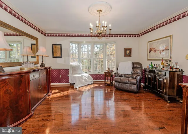 a living room with furniture or chandelier and a wooden floor
