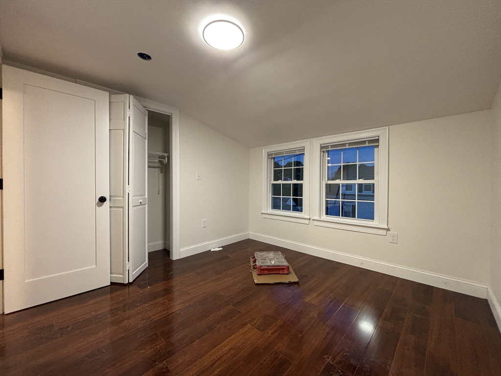 4 Appleton Street, Unit D Quincy, MA 02171 - Photo 10 of 12 an empty room with wooden floor and windows