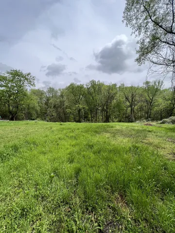 a view of a green field with wooden fence