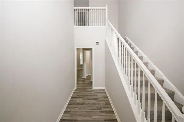 a view of a hallway with wooden floor and staircase