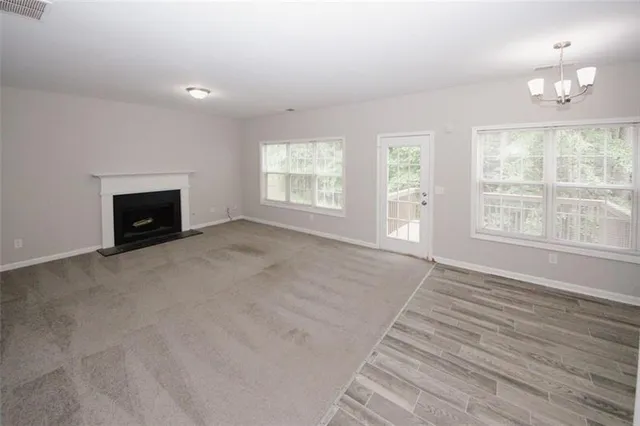 an empty room with windows and fireplace