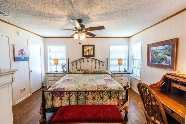 a bedroom with a bed a chandelier and dresser