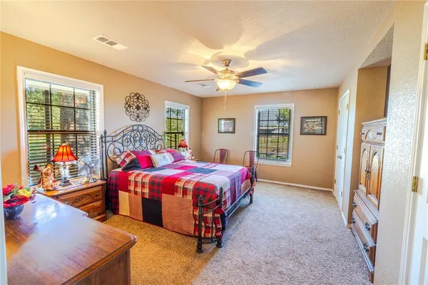 a spacious bedroom with a bed and a chandelier