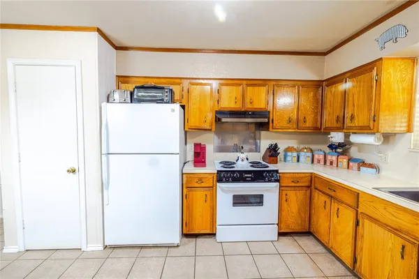 a kitchen with a white refrigerator stove and a sink