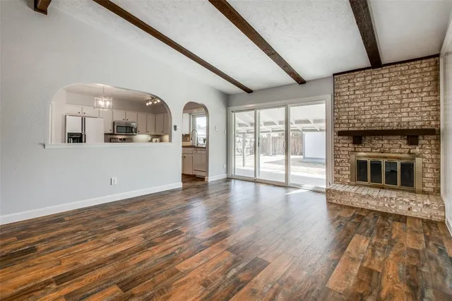 a view of a living room with wooden floor and fireplace