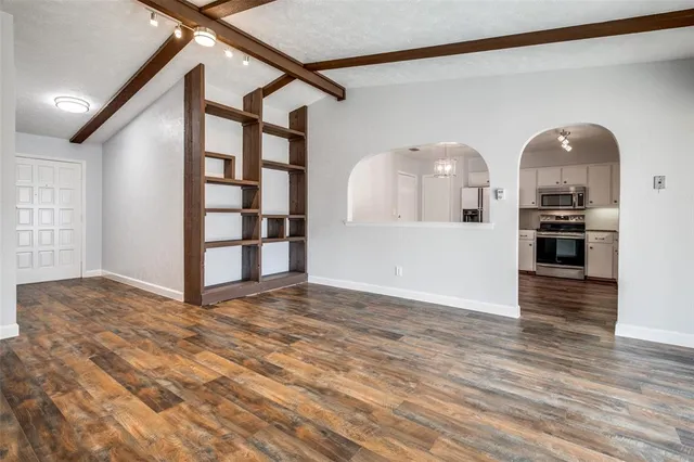 a view of empty room with kitchen and window