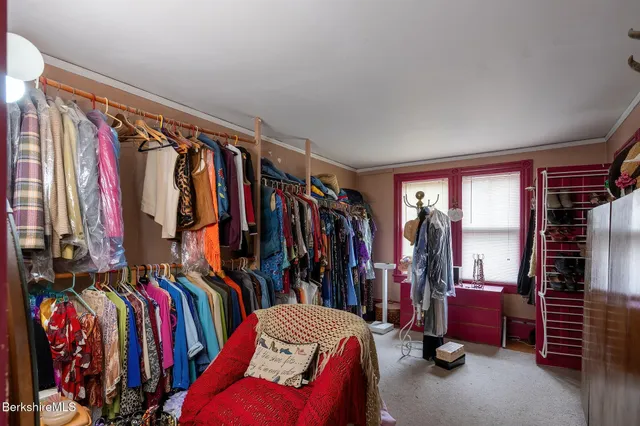 a view of walk in closet with clothes