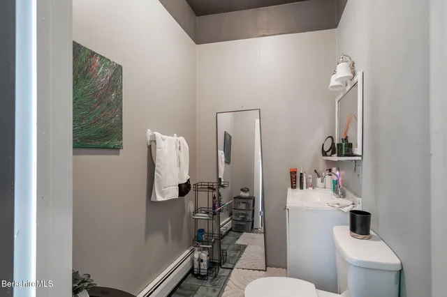 a bathroom with a toilet sink and mirror