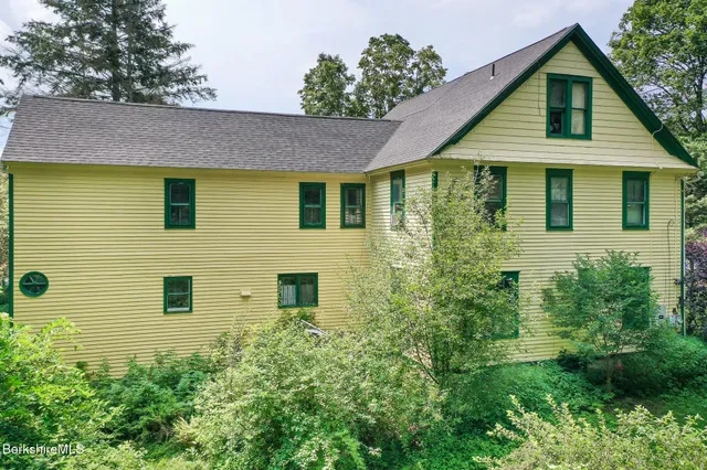 a view of a brick house next to a yard