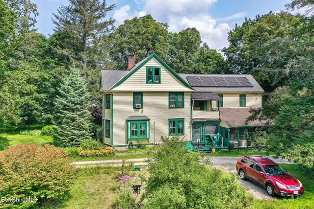 a front view of a house with a yard and trees