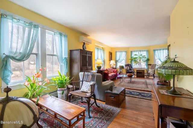 a living room with furniture a lamp a rug and a large window
