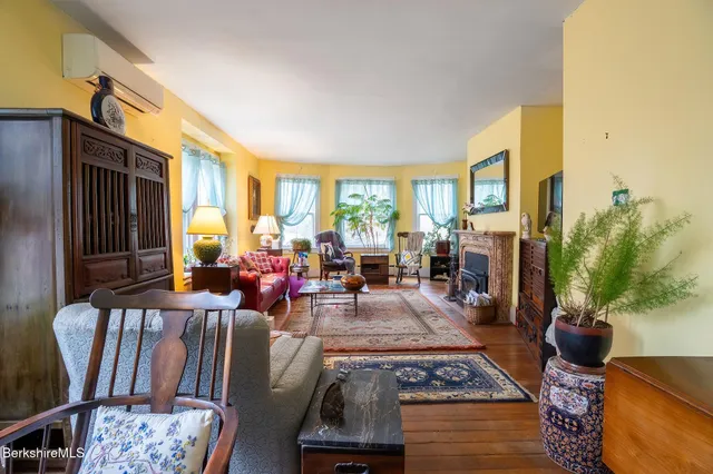 a living room with furniture fireplace and a large window