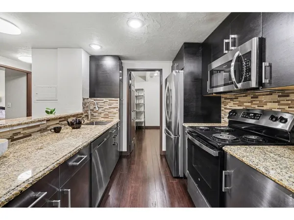a kitchen with stainless steel appliances granite countertop a stove and a sink