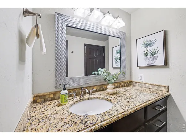 a bathroom with a granite countertop sink and a mirror
