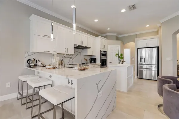 a kitchen with kitchen island a sink stove and white cabinets