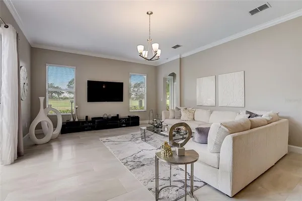 a living room with furniture a flat screen tv and a window
