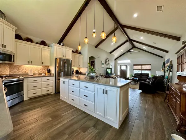 a kitchen with granite countertop a stove cabinets and wooden floor