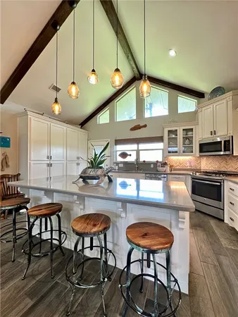 a kitchen with stainless steel appliances granite countertop a stove a sink and a refrigerator