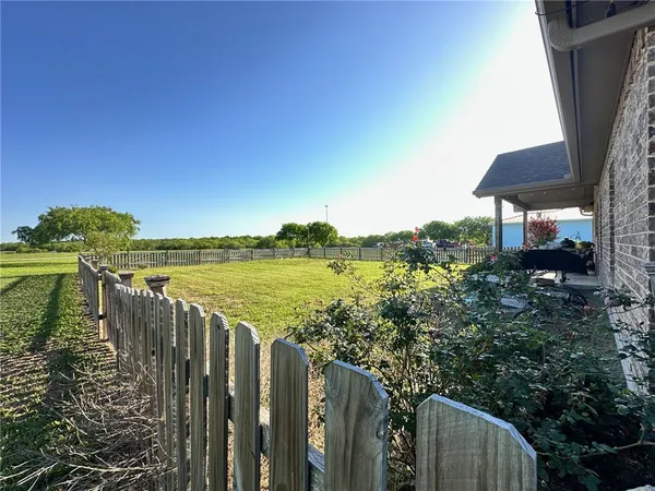 a view of a lake with a floor to ceiling window and wooden fence