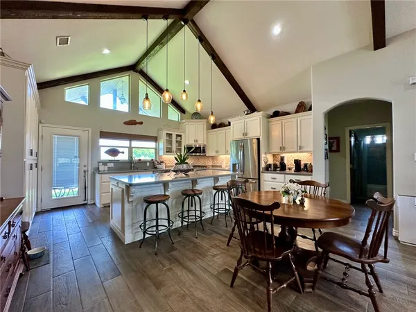 a dining room with stainless steel appliances kitchen island a table and chairs