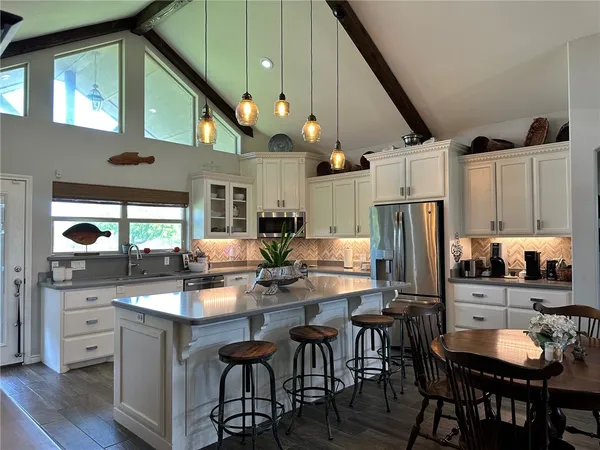 a kitchen with stainless steel appliances a dining table and chairs