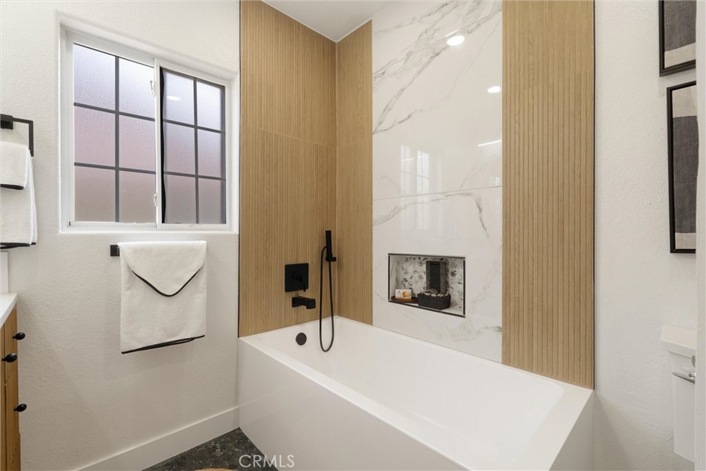 1675 West Mells Lane Anaheim, CA 92802 - Photo 15 of 46 a bathroom with a tub a sink and mirror