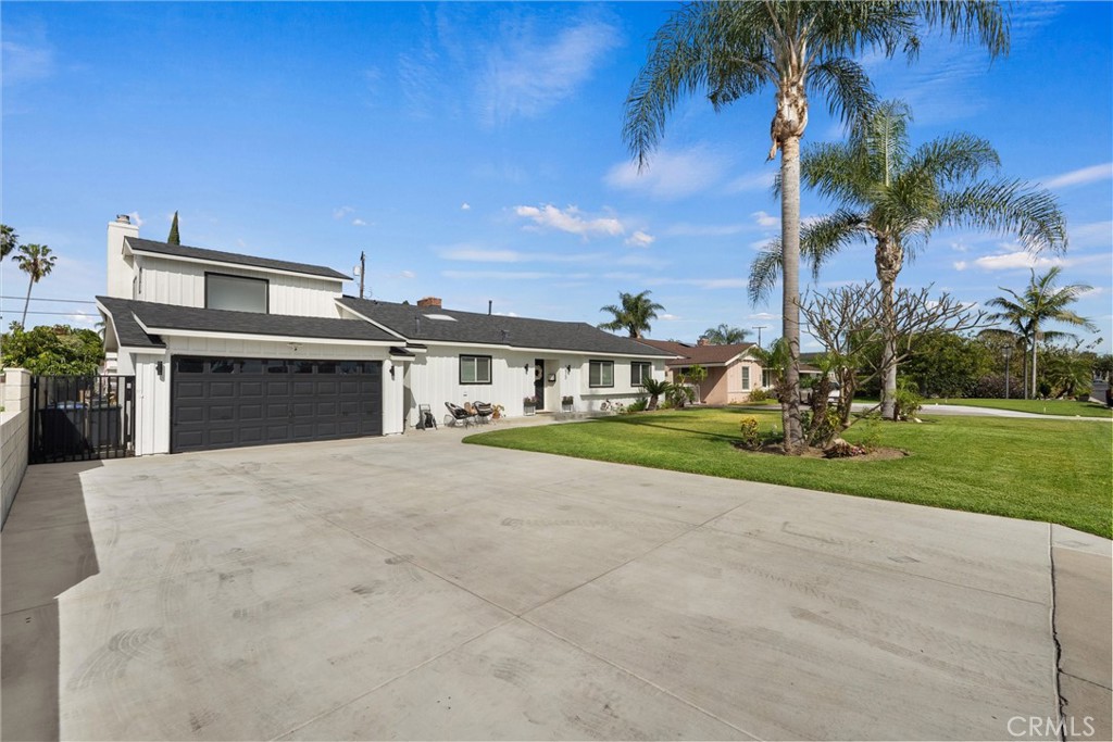 1675 West Mells Lane Anaheim, CA 92802 - Photo 3 of 46 a front view of a house with a yard and garage