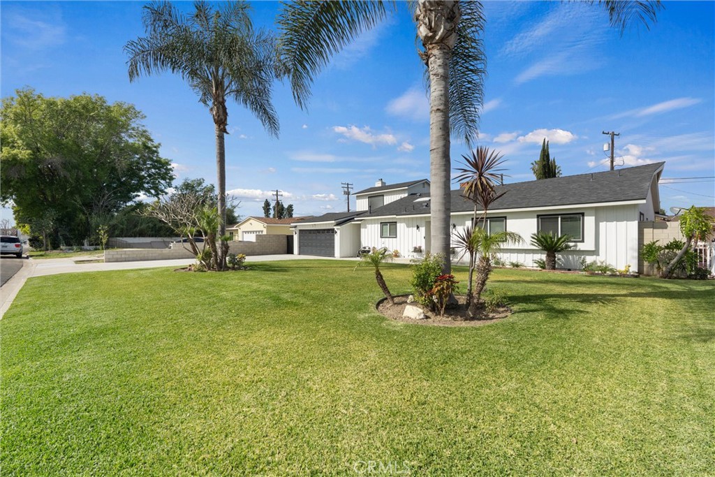 1675 West Mells Lane Anaheim, CA 92802 - Photo 4 of 46 a front view of a house with garden and trees