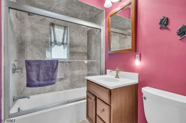 a view of an empty room with wooden floor and closet