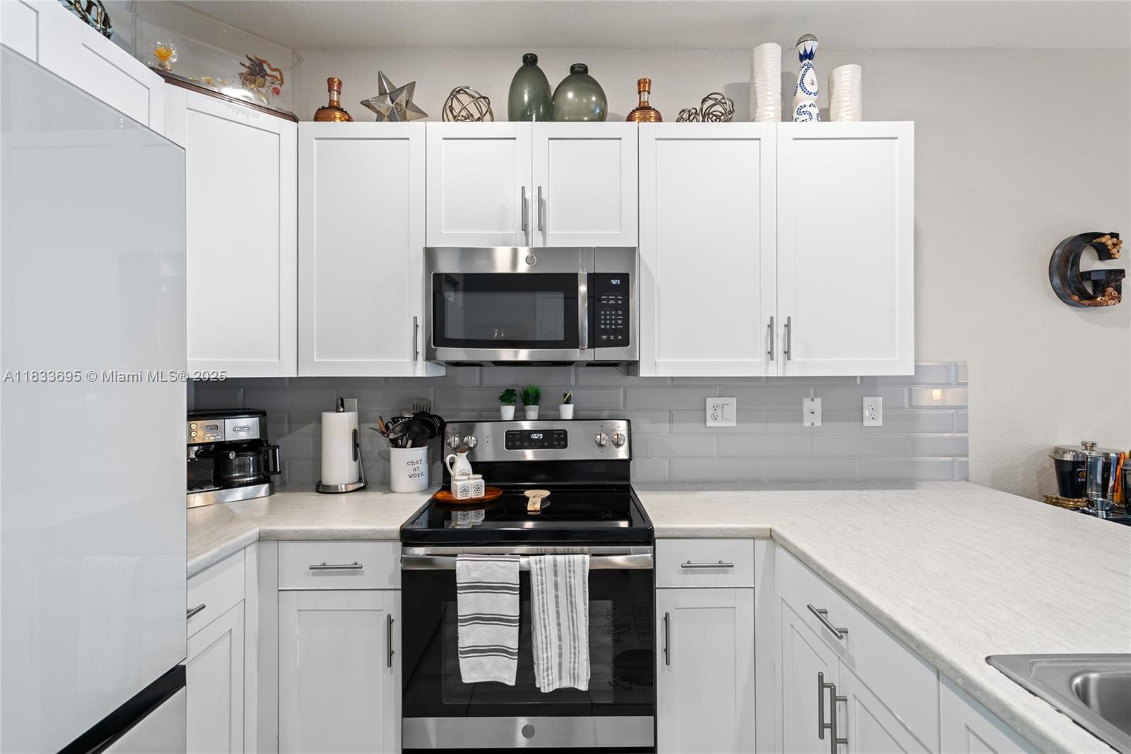 10468 West 33rd Lane Hialeah, FL 33018 - Photo 17 of 77 a kitchen with a sink a stove and cabinets