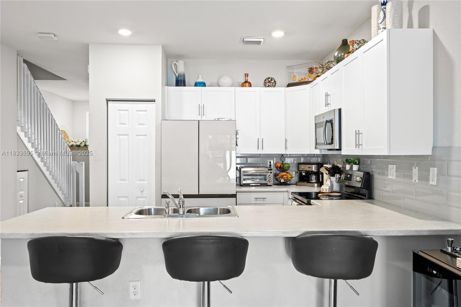 10468 West 33rd Lane Hialeah, FL 33018 - Photo 19 of 77 a kitchen with stainless steel appliances granite countertop a sink and a refrigerator