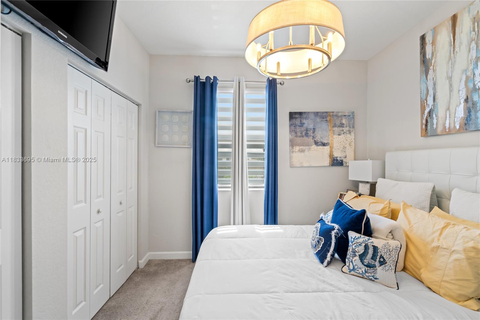 10468 West 33rd Lane Hialeah, FL 33018 - Photo 42 of 77 a bedroom with bed and a chandelier