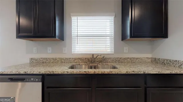 a kitchen with granite countertop a sink and a microwave