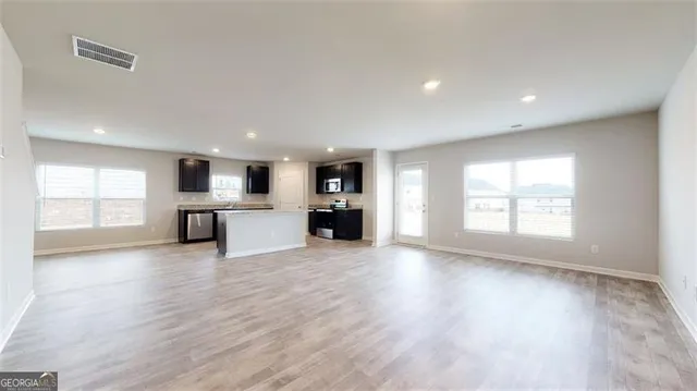 a view of a big room with wooden floor and windows