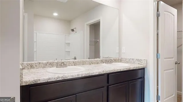 a bathroom with a granite countertop sink and a mirror