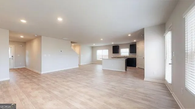 a view of kitchen with kitchen island a sink wooden floor and a refrigerator