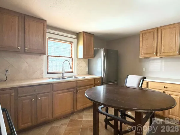 a kitchen with a table chairs refrigerator and cabinets