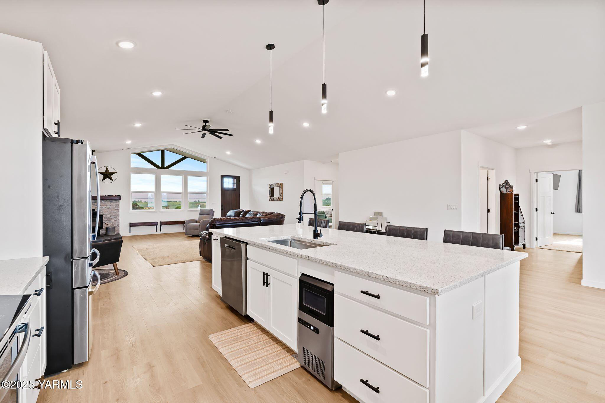12907 Douglas Road Yakima, WA 98908 - Photo 11 of 44 a large kitchen with kitchen island a stove a sink a refrigerator and a wooden floor