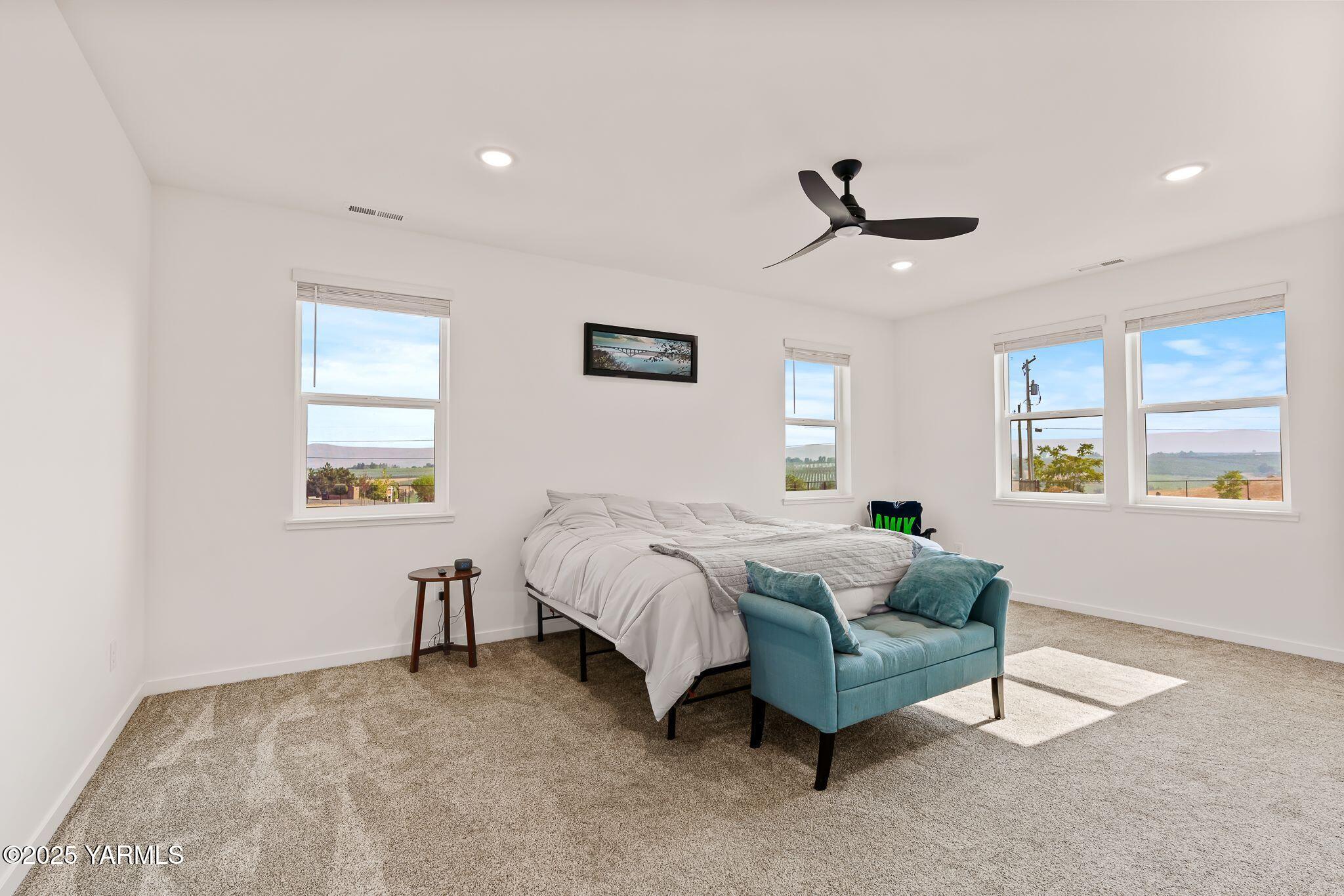 12907 Douglas Road Yakima, WA 98908 - Photo 16 of 44 a spacious bedroom with a bed a chandelier and a window