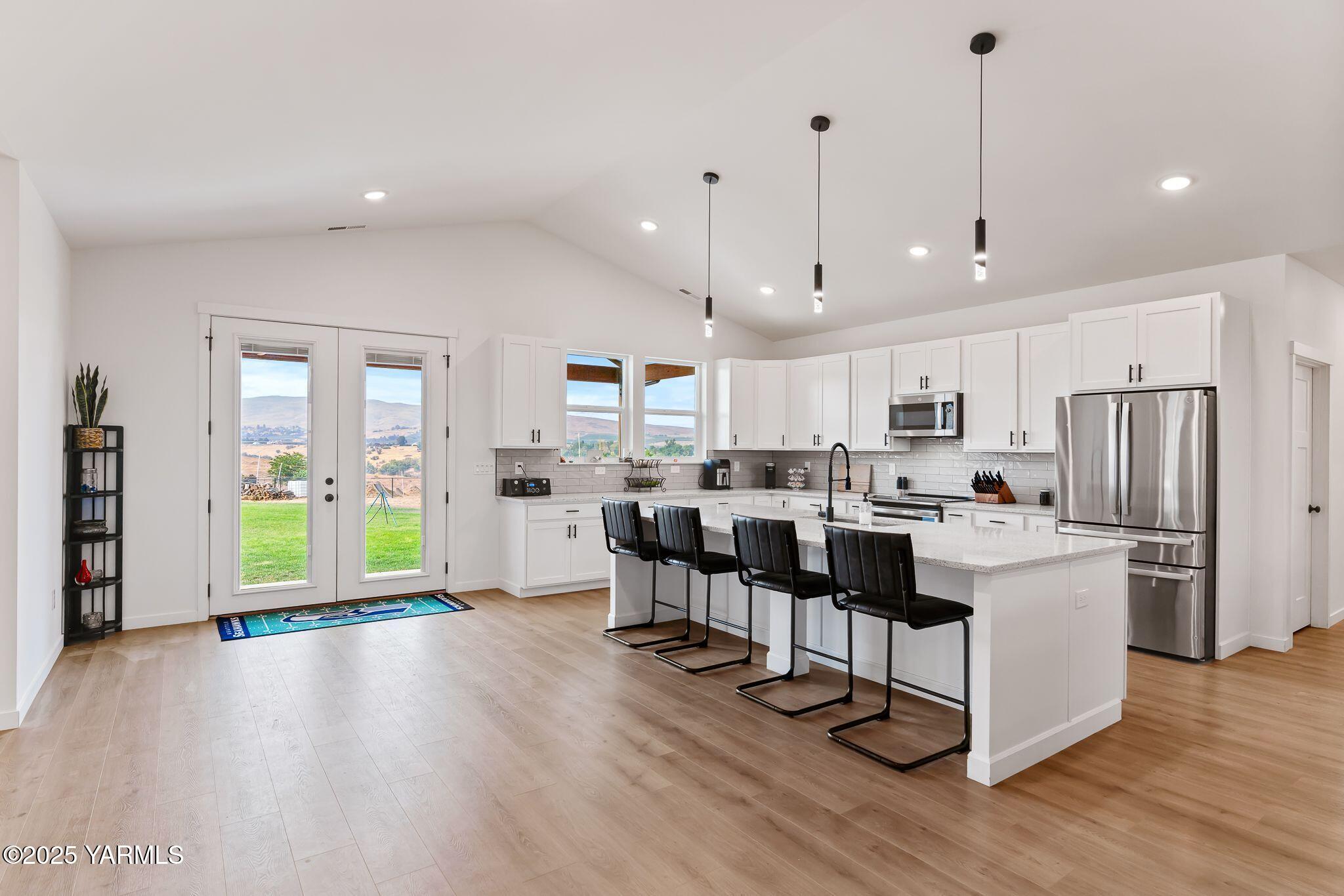 12907 Douglas Road Yakima, WA 98908 - Photo 7 of 44 a kitchen with stainless steel appliances kitchen island wooden floors refrigerator and stove