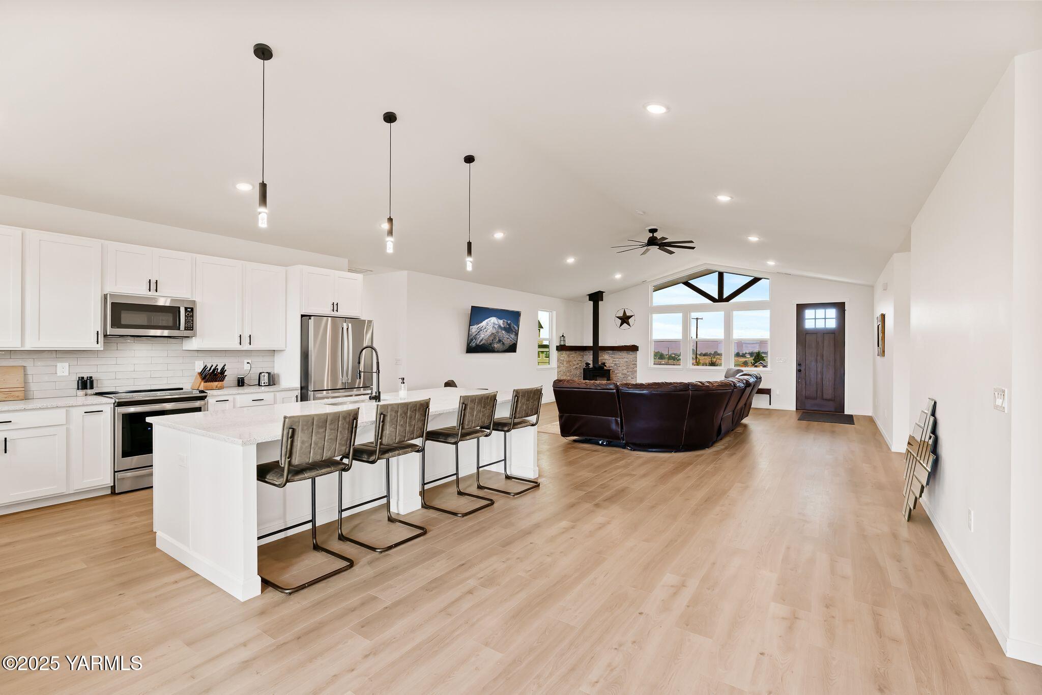 12907 Douglas Road Yakima, WA 98908 - Photo 8 of 44 a living room with stainless steel appliances kitchen island granite countertop a sink a stove and a wooden floors