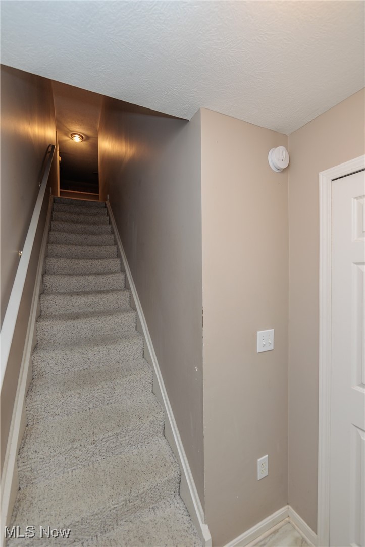 28360 Center Ridge Road, Unit 2210 Westlake, OH 44145 - Photo 5 of 45 Stairs featuring a textured ceiling and carpet floors