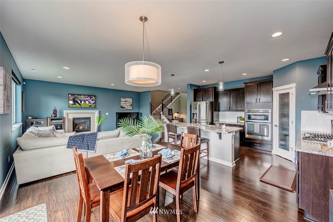 19310 37th Drive Southeast Bothell, WA 98012 - Photo 5 of 22 a view of a dining room and livingroom with furniture wooden floor a rug a fireplace and a chandelier