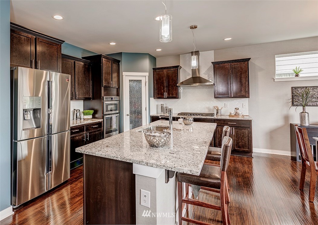 19310 37th Drive Southeast Bothell, WA 98012 - Photo 8 of 22 a kitchen with stainless steel appliances granite countertop a refrigerator a stove a sink a dining table and chairs