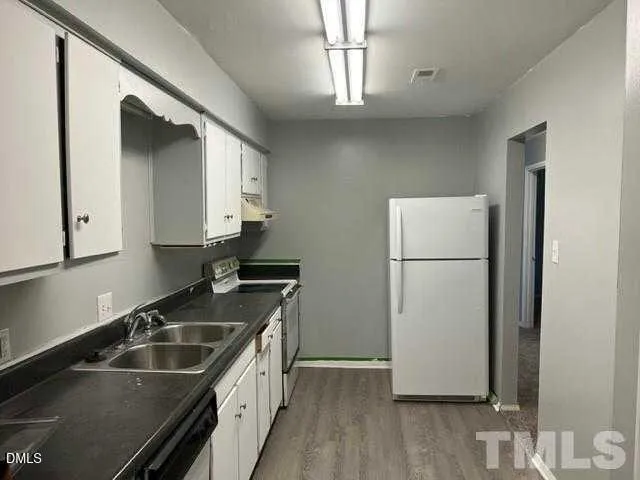 a kitchen that has a sink and a refrigerator