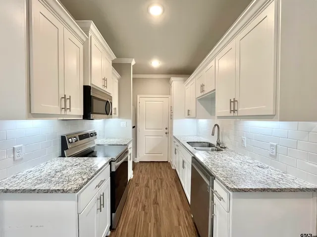 a kitchen with stainless steel appliances granite countertop a sink stove and refrigerator